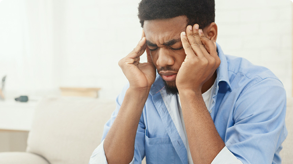 Man holding his head suffering from migraine.
